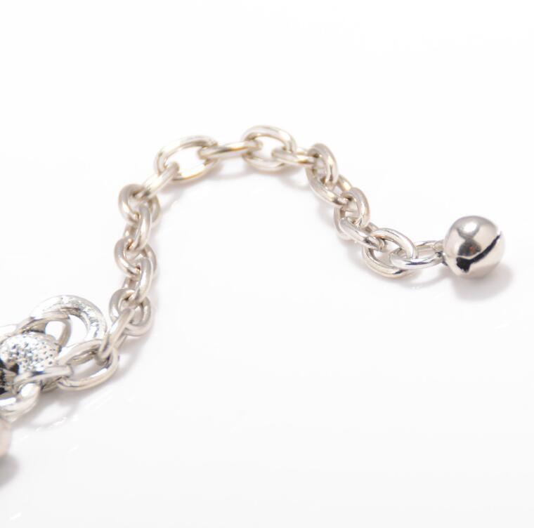 Silver chain bracelet with a heart charm on a white background
