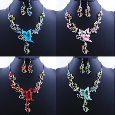 Set of butterfly-themed necklaces and earrings on black mannequin busts.
