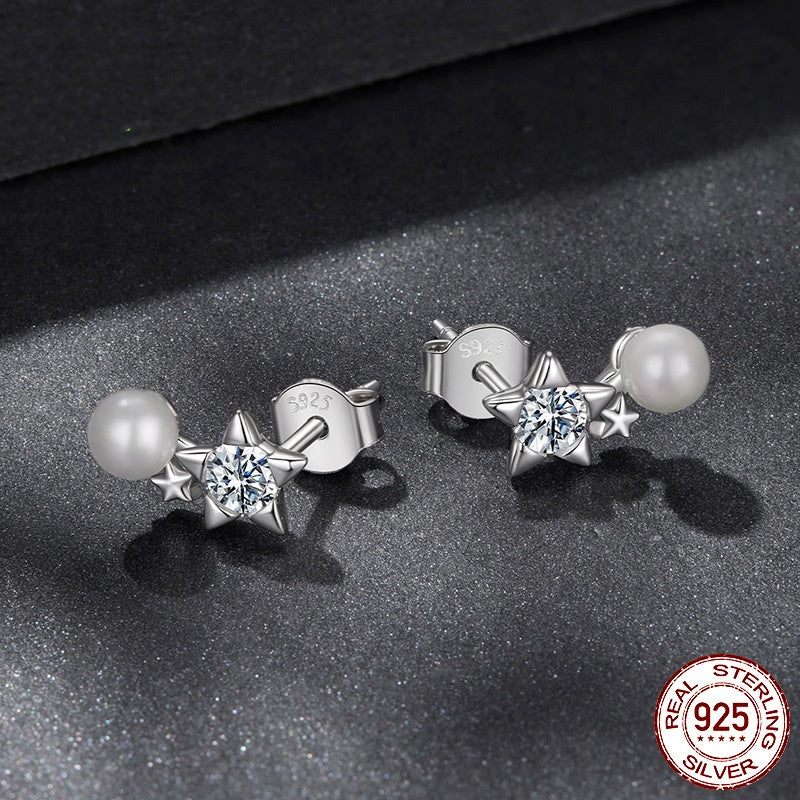 Pair of silver star and pearl earrings on a dark surface with '925 Sterling Silver' stamp.