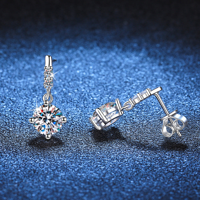 Pair of silver earrings on a blue textured background