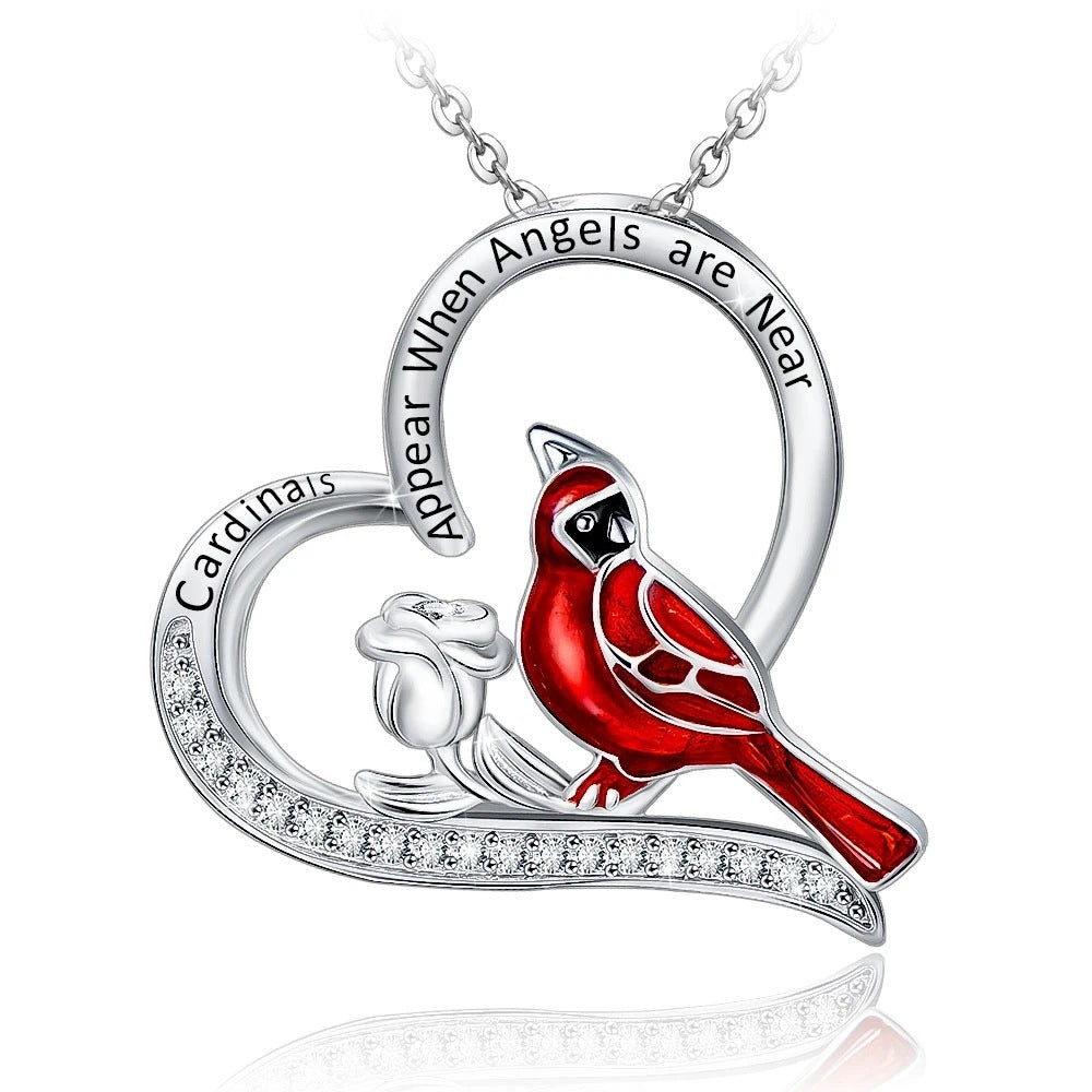 Pendant necklace with red bird design and engraved text on a white background
