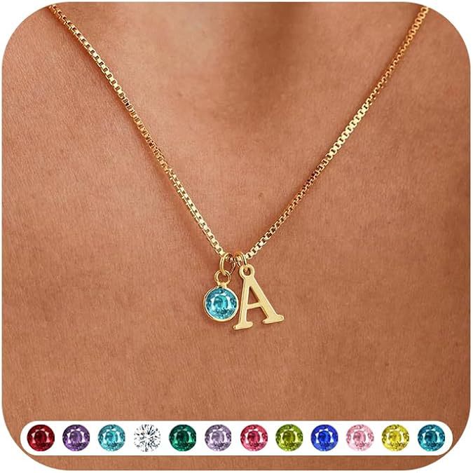 Gold necklace with a blue gemstone and letter 'A' pendant on a brown background.