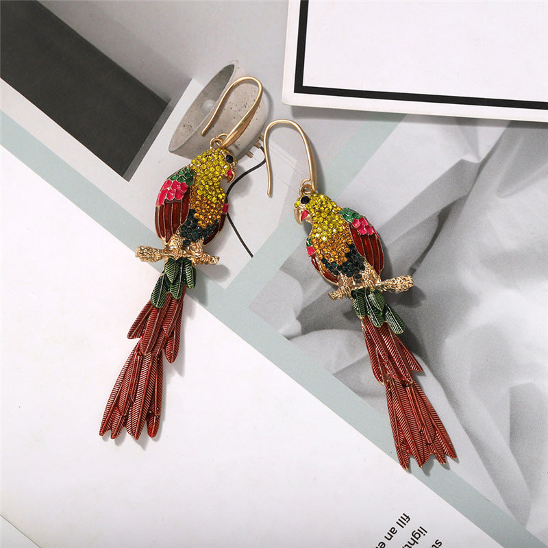Colorful parrot-shaped earrings on a white surface
