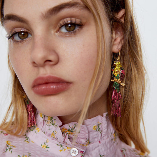 Close-up of a woman wearing colorful earrings with a neutral background