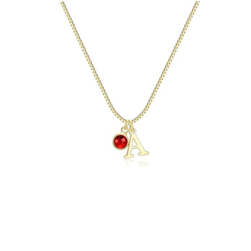 Gold necklace with a red gemstone and letter 'A' pendant on a white background