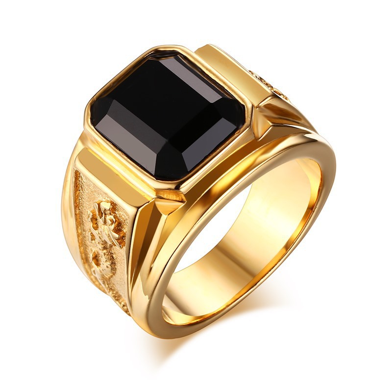 Gold ring with a black gemstone on a white background