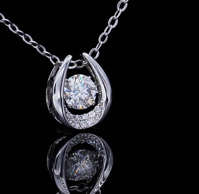 Silver necklace with a diamond pendant on a black background