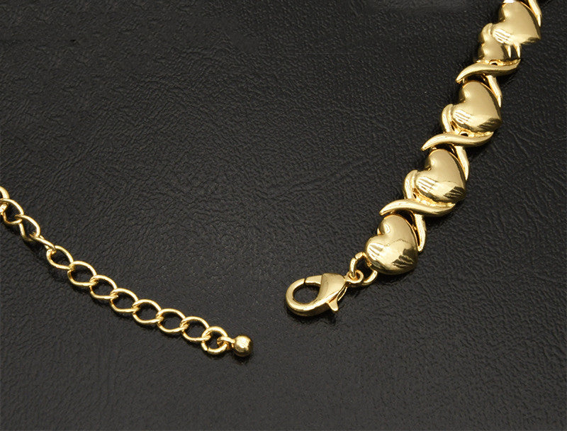 Gold bracelet with heart-shaped links on a black background