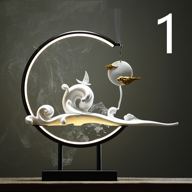 Decorative lamp with white swirl design on a dark background  incense burner