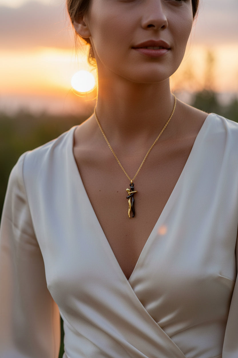 Gold and black pendant necklace on a white background