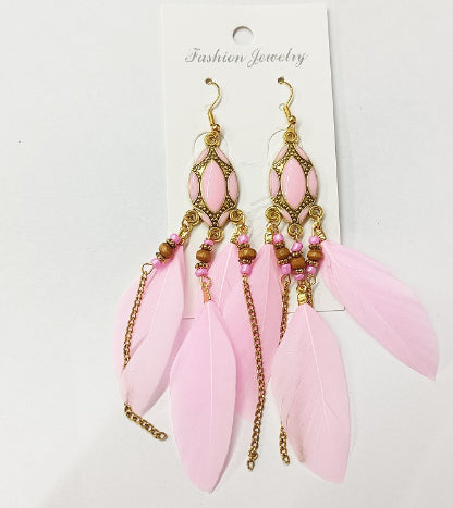 Pink feather earrings with gold accents on a white card labeled 'Fashion from Nested Wisdom Jewelry'.