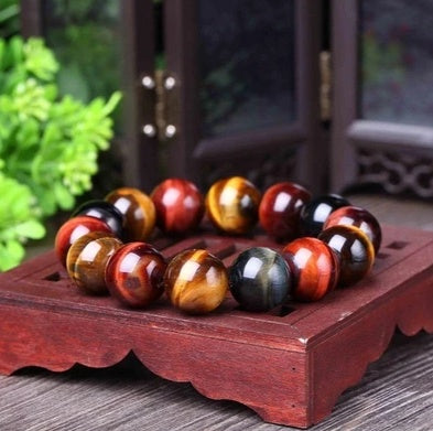 Eye of the tiger beaded bracelet on a wooden stand with a blurred background
