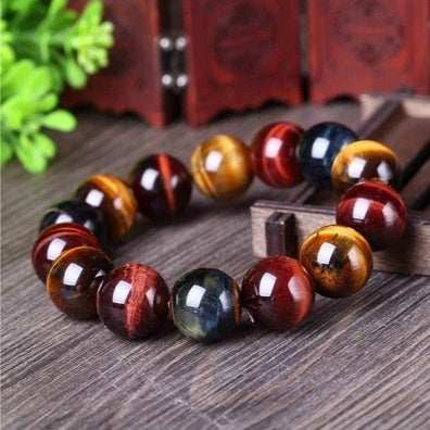 Eye of the tiger beaded bracelet on a wooden surface with a wooden box in the background