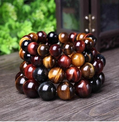Stack of multicolored beaded bracelets on a wooden surface with a blurred natural background