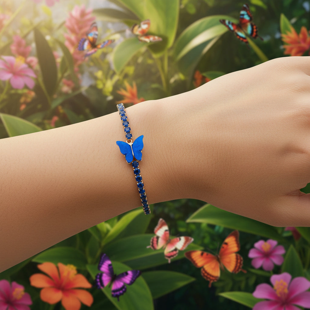 Gold bracelet with blue gemstones and a blue butterfly charm on a gray background