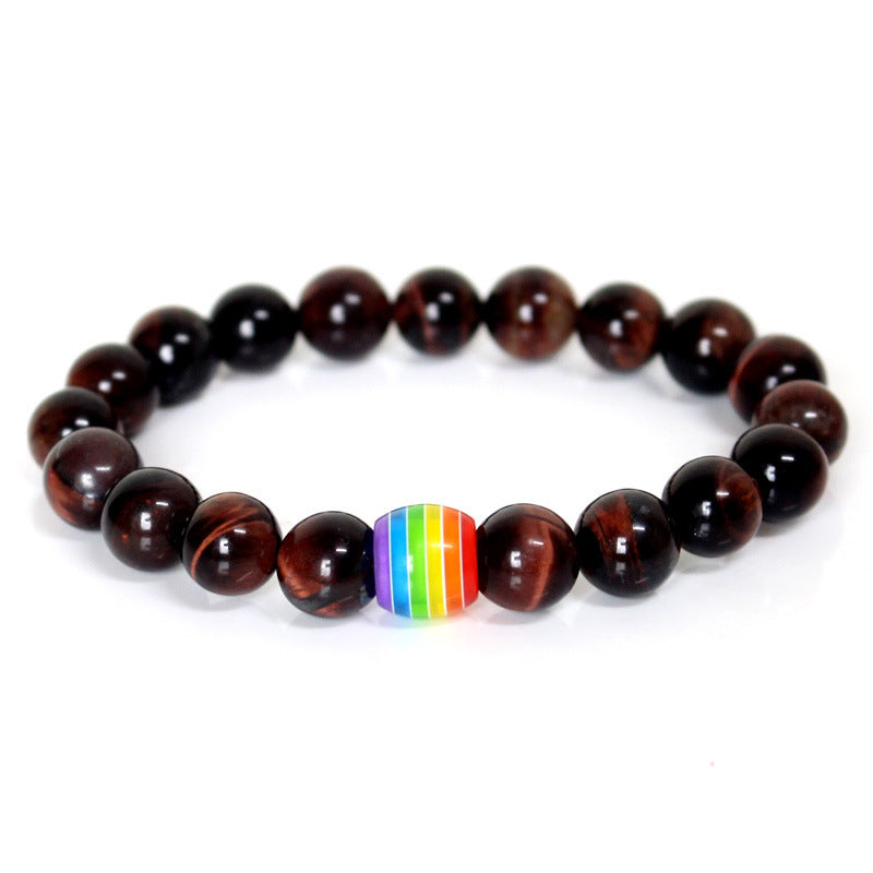 Beaded bracelet with a rainbow charm on a white background