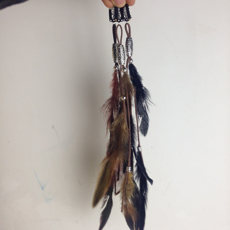 Feathered keychain with beads on a plain background