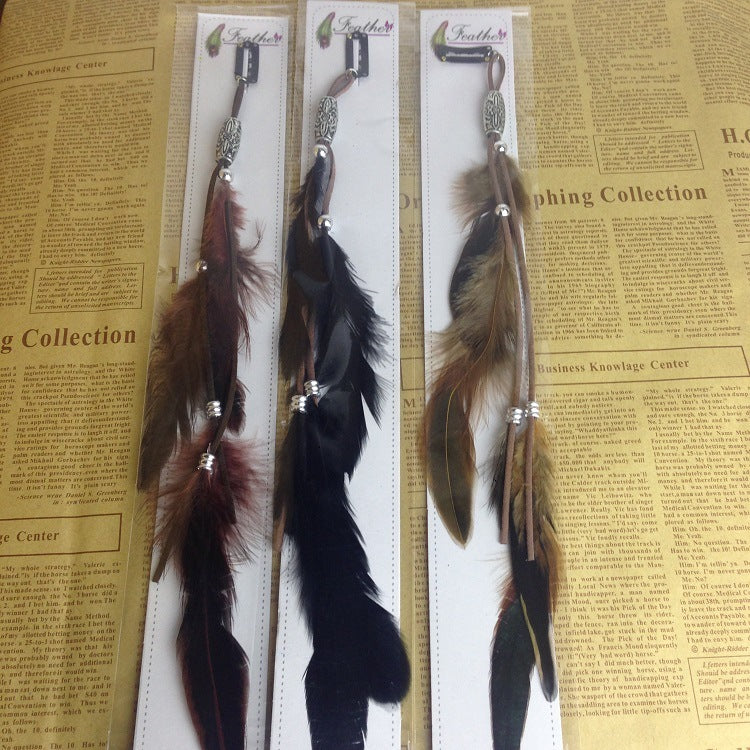 Three feather hair accessories on a ruler with a newspaper background