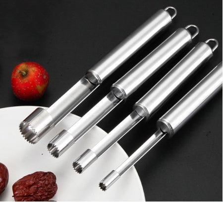 Set of four metal fruit corers on a dark background with apples and dates.