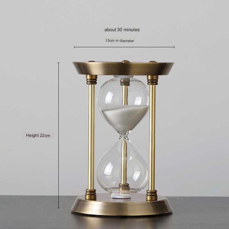 Brass hourglass with measurements on a gray background