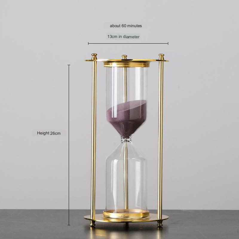 Gold and glass hourglass with measurements on a gray background