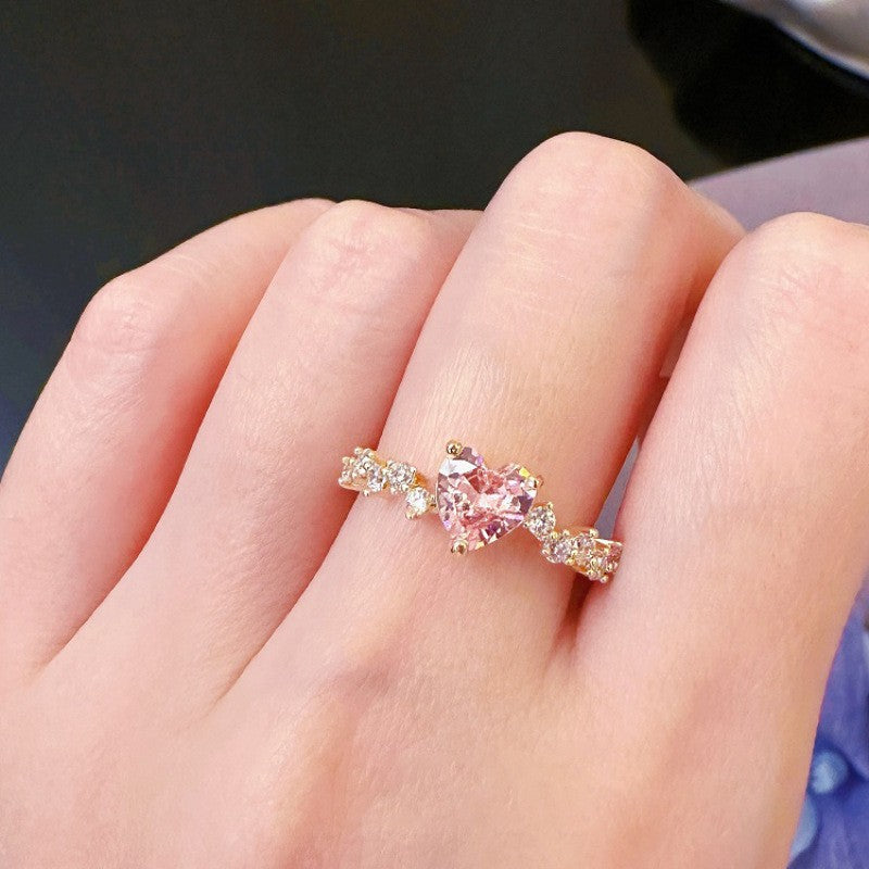 Pink gemstone ring on a finger with a blurred background