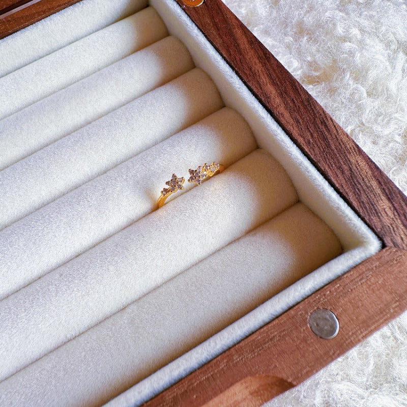 Gold ring with diamonds on a wooden jewelry box with white interior