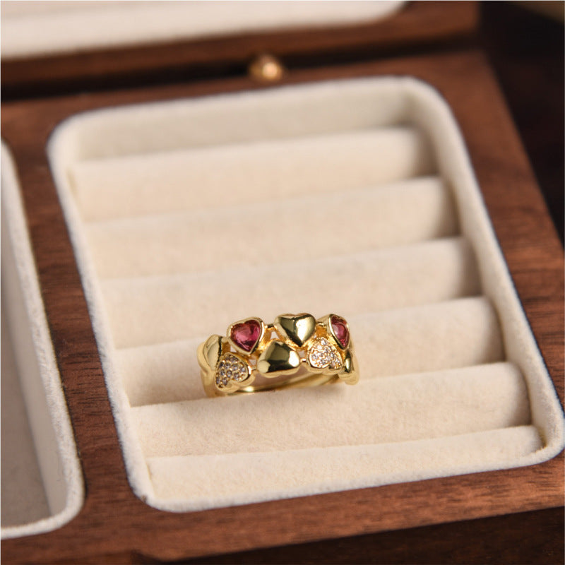 Gold ring with red gemstones in a wooden jewelry box