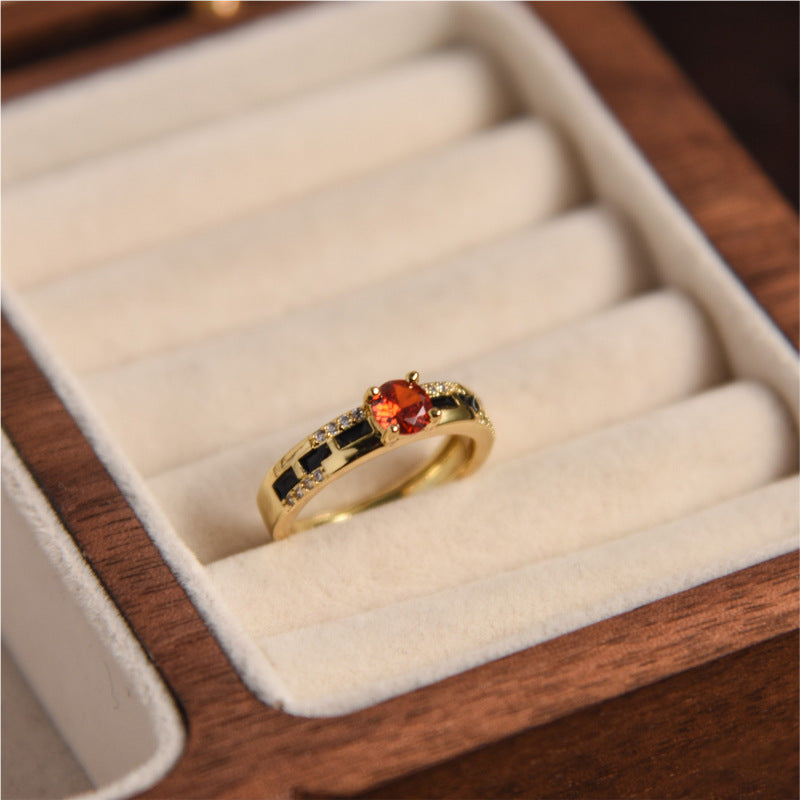 Gold ring with red gemstone in a wooden jewelry box