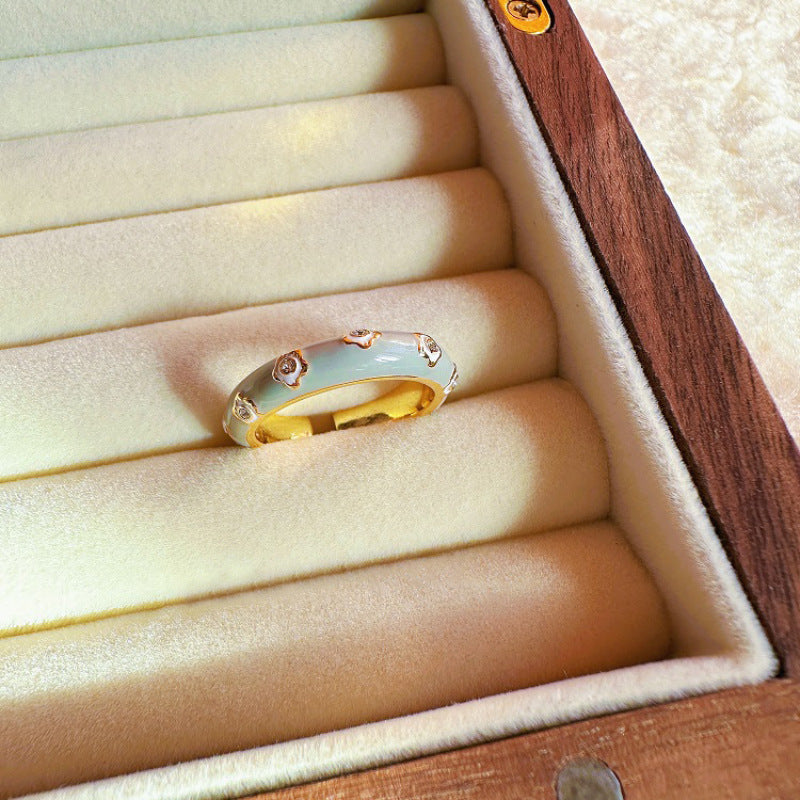 Gold ring with rose gold accents on a wooden jewelry box