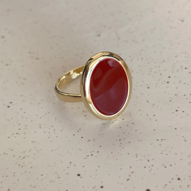 Gold ring with a red stone on a speckled surface