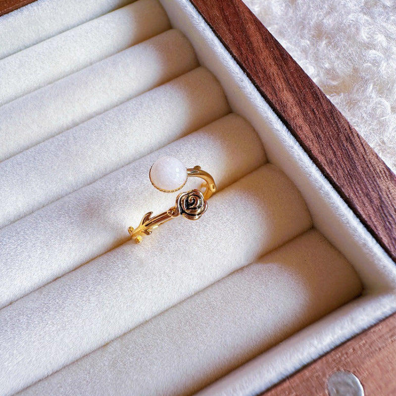 Gold earring on a white jewelry cushion in a wooden box