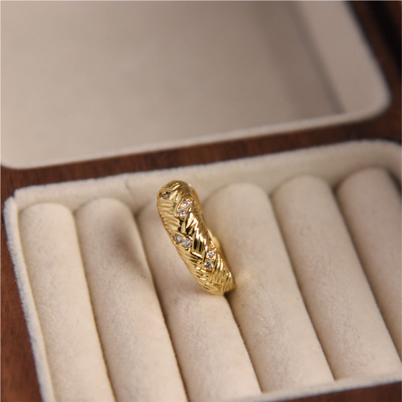 Gold ring with intricate design in a jewelry box