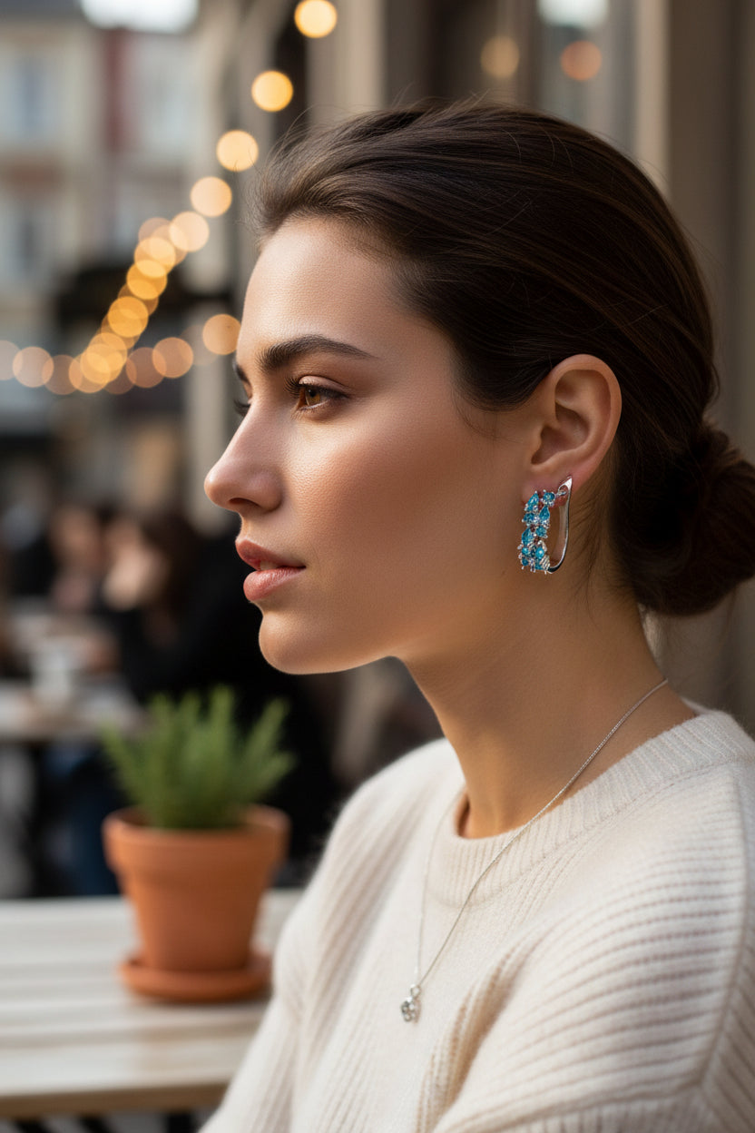 Silver hoop earrings with blue gemstones on a woman in public