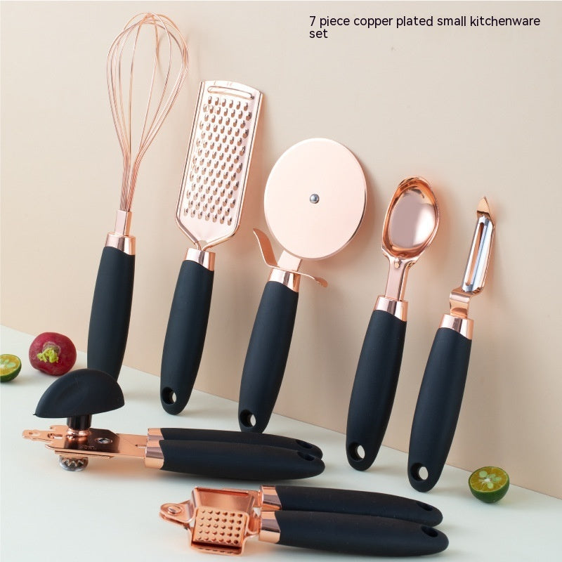 Set of 7 copper-plated kitchen utensils with black handles on a light background.