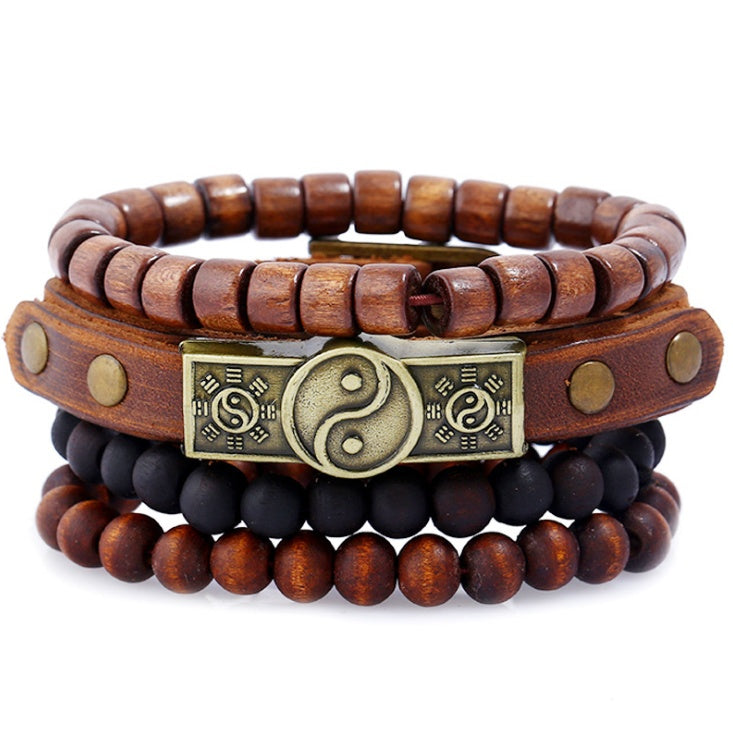 Stack of wooden beaded bracelets with a central brass yin yang symbol