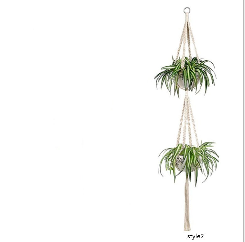 Macrame plant hanger with two potted plants on a white background