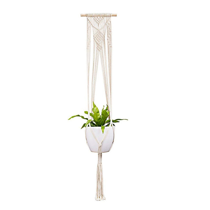 Macrame plant hanger with a white pot and green plant on a white background