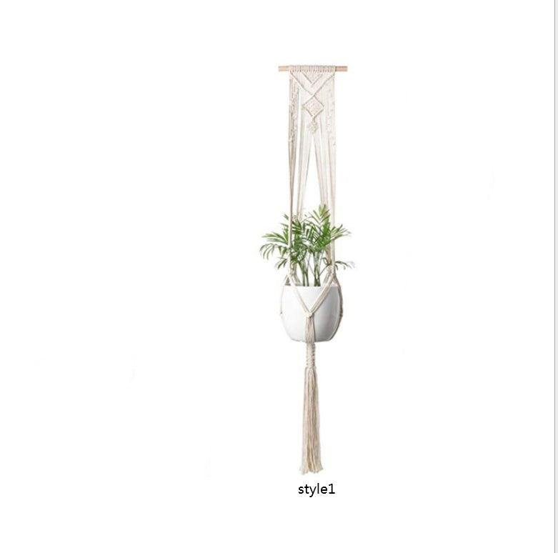 Macrame plant hanger with a white pot and plant on a white background