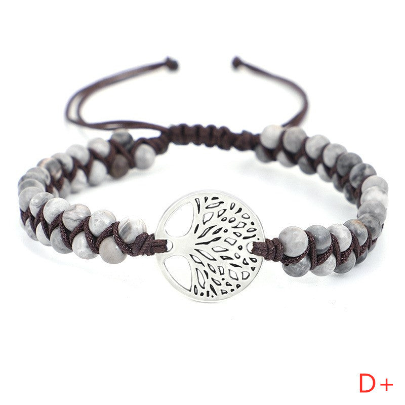 Bracelet with gray beads and silver tree-of-life charm on a white background