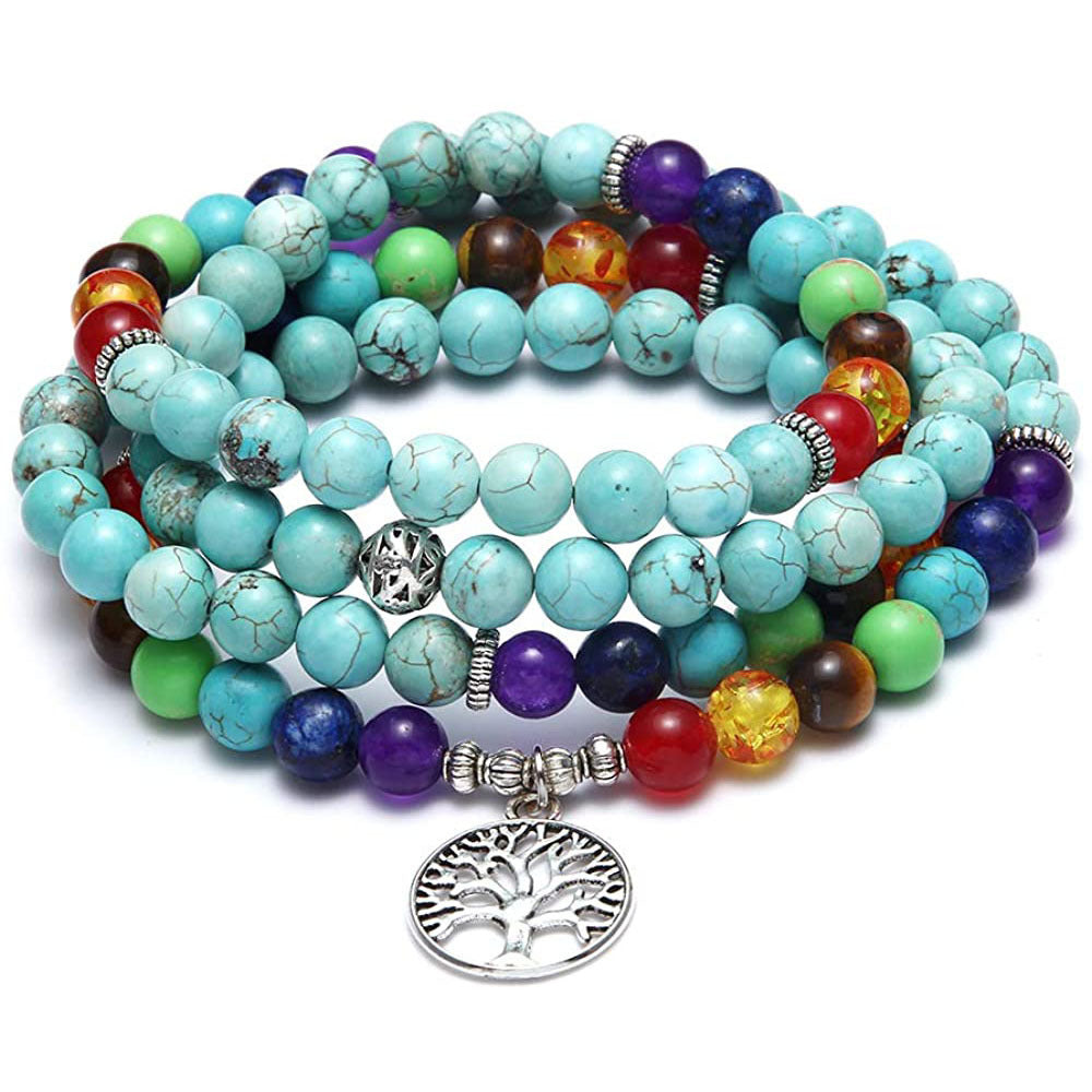 Multicolored beaded bracelets with a silver tree of life charm on a white background