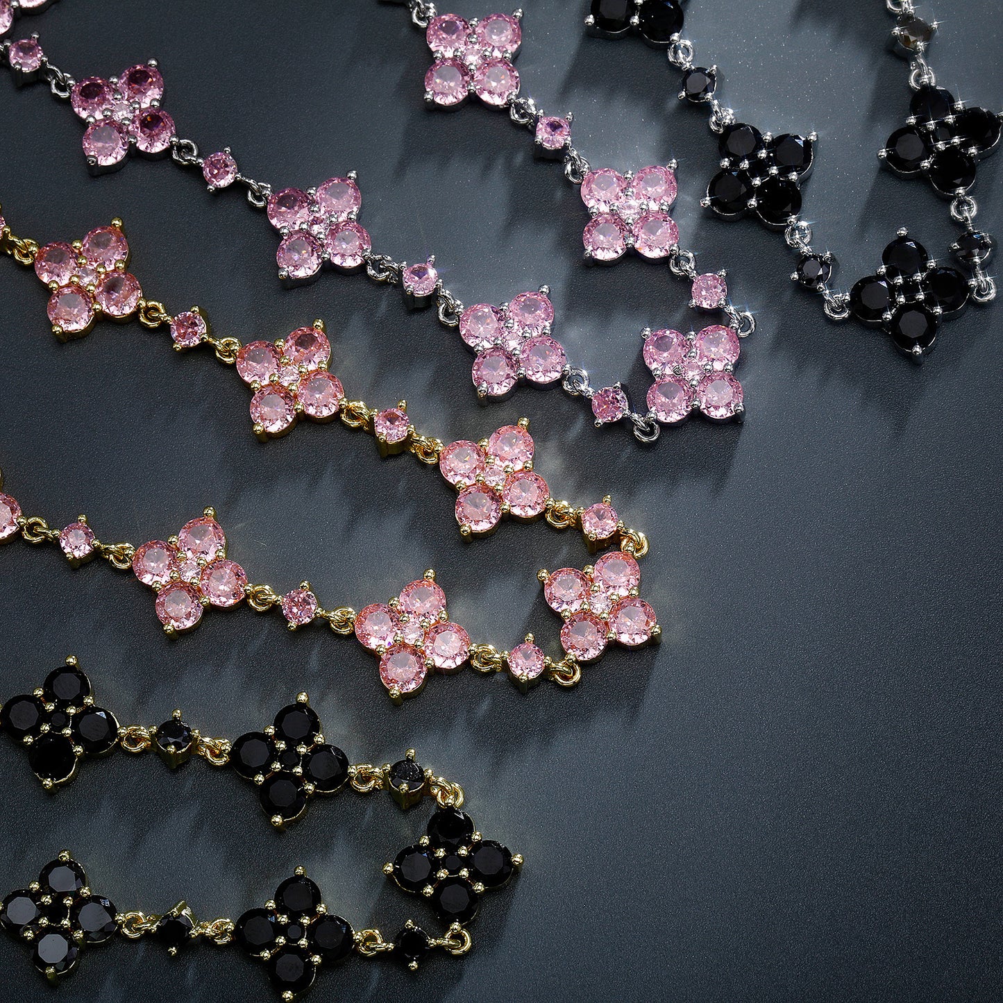 Necklaces with pink and black gemstones on a dark surface