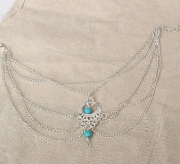 Multistrand necklace with turquoise stones on a beige fabric background