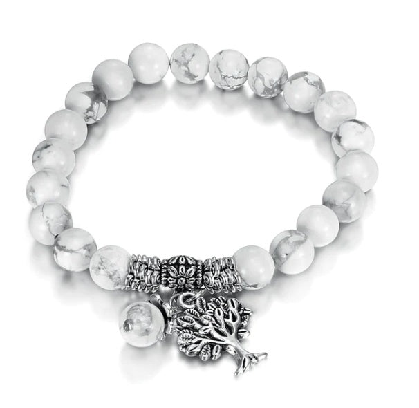 Bracelet with white beads and silver tree of life charm on a white background